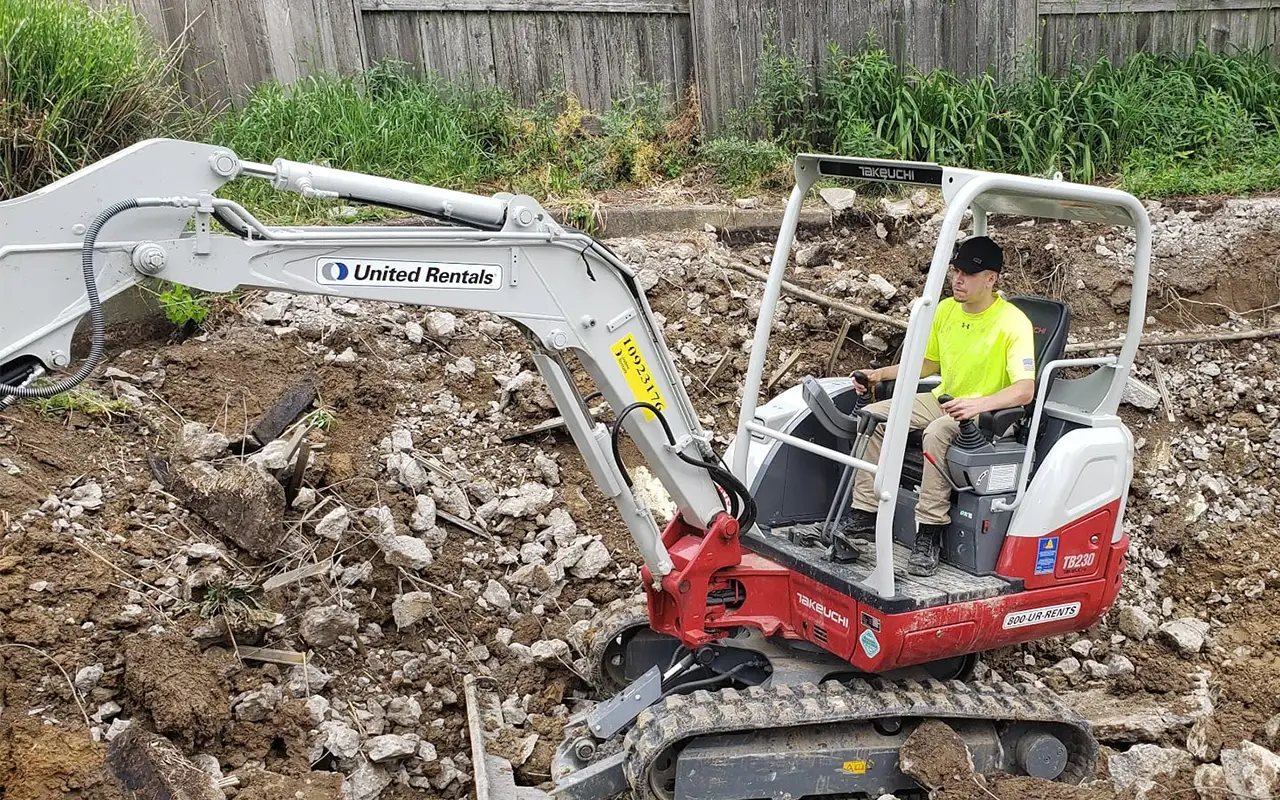 Excavator performing a pool fill-in/pool filling