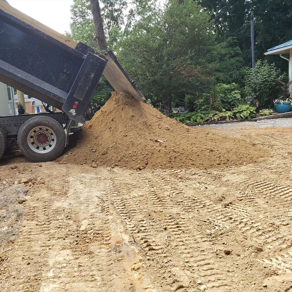 A dump truck unloading the screened soil for above ground pool hole