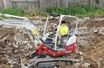 Heavy equipment clears large pieces of concrete from the pool demolition Large concrete debris from pool demolition being cleared