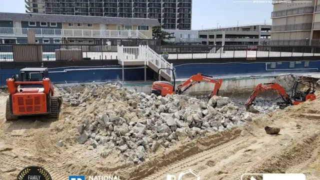 Two excavators clearing rocks from a sand-covered pool area, while preparing the ground for landscaping.