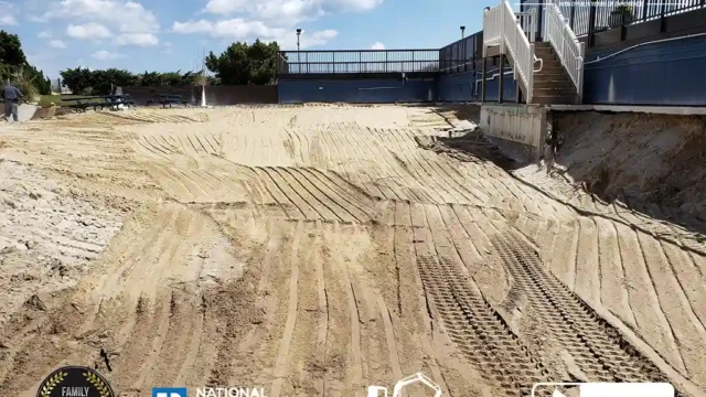 A flat area with freshly graded soil, preparing the site for new landscaping after pool removal.