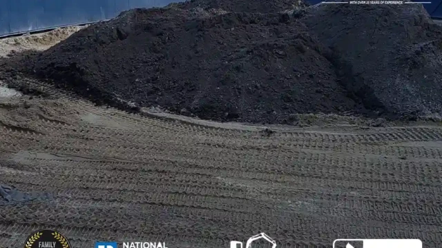 A large pile of soil near the pool site, waiting to be spread across the area for final landscaping.