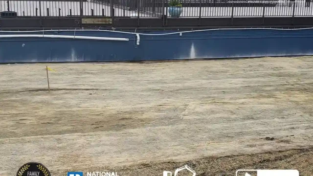 Final restoration of the site where a pool has been removed, with smooth soil and fresh straw laid across the yard.