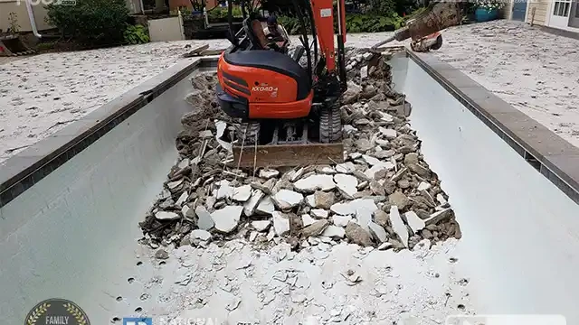 Step 5: We began drilling holes in the bottom of the pool and demolished the side facing the pathway. We drilled holes in the pool bottom and demolished the pool wall facing the pathway.