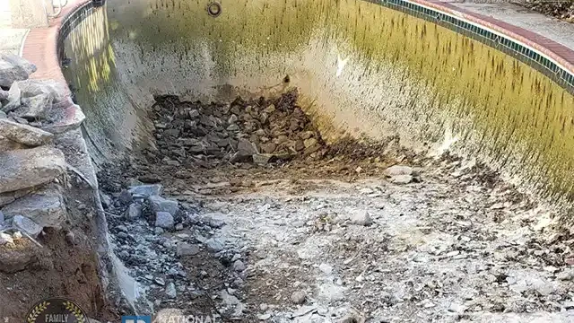 Step 9: Once the water was drained, we resumed breaking up the remaining sections of the pool's bottom. Once drained, we broke more sections of the pool’s bottom.