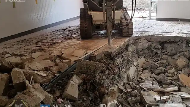 Skid loader with jackhammer tearing the deck of the pool